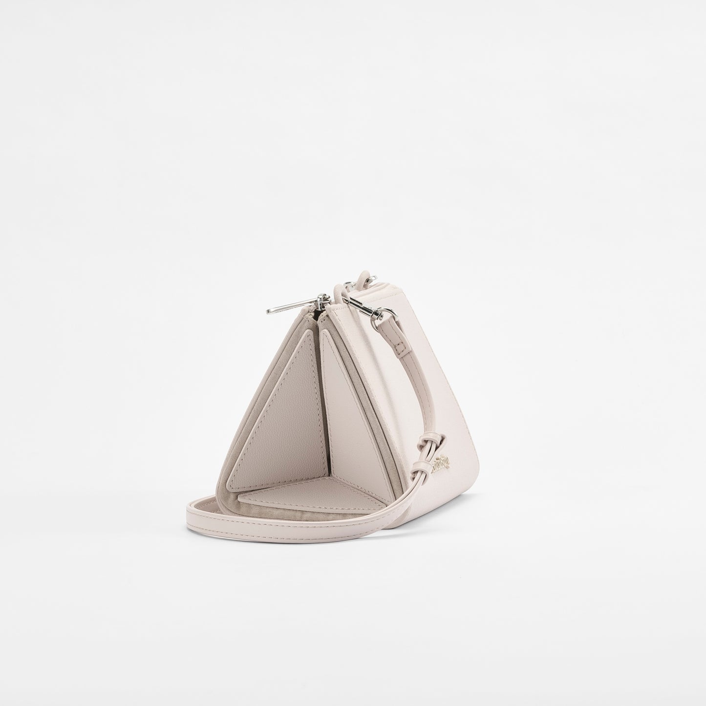 Side view of HuluBulu pale pink-colored om & out handbag featuring unique multi-compartment structure, silver hardware, and adjustable strap.